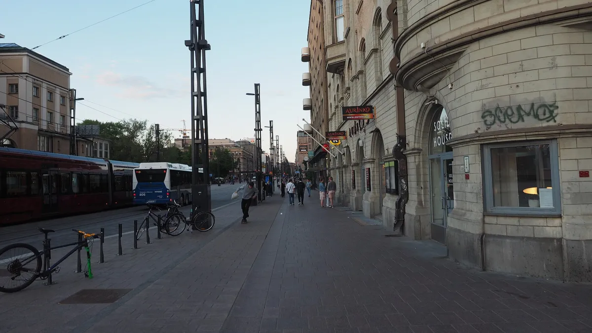 A view of the street Hämeenkatu in central Tampere, Finland with a tram and a bus driving on the street (both visible on the extreme left) on a sunny evening in June 2022.