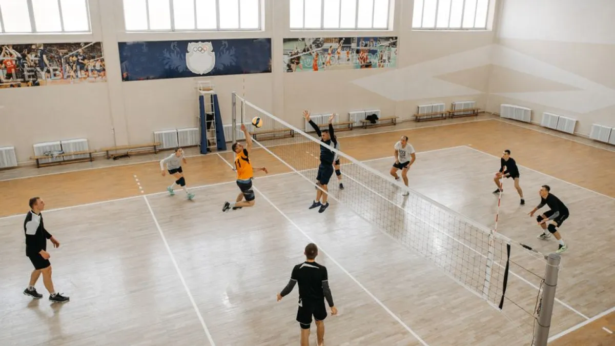 High-energy indoor volleyball game with teams competing intensely on the court.