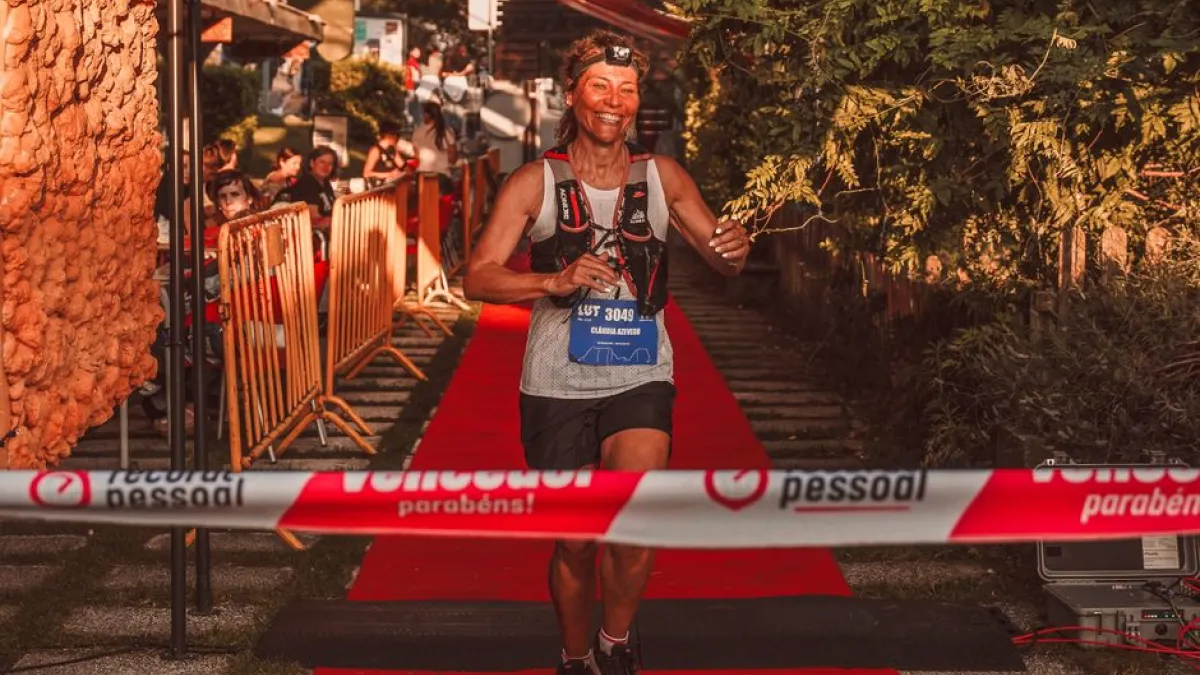 A joyful woman crossing the race finish line triumphantly outdoors.