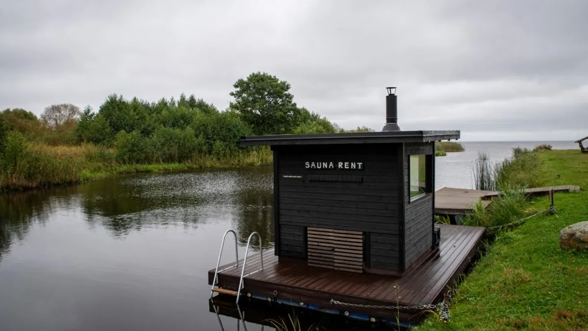 A floating sauna on a peaceful lakeside in Estonia, perfect for relaxation and retreat.