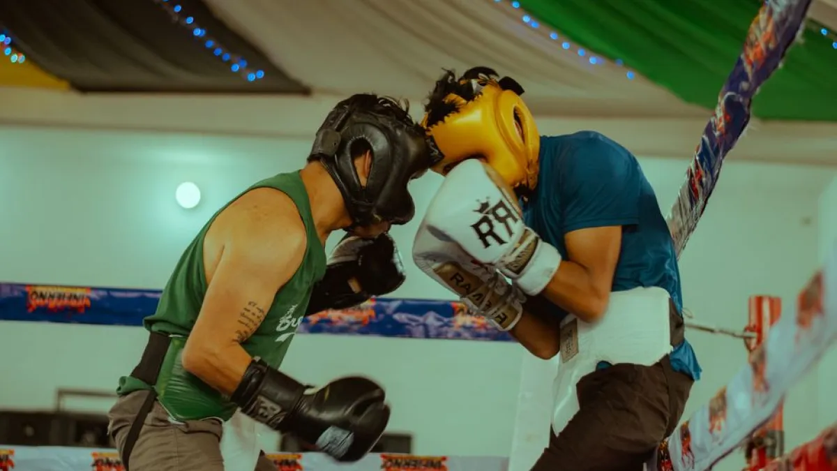 Two boxers engaged in a thrilling match wearing protective headgear and gloves.