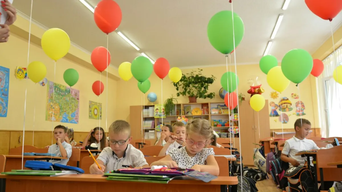 Two diverse elementary school children classmates studying together at desk