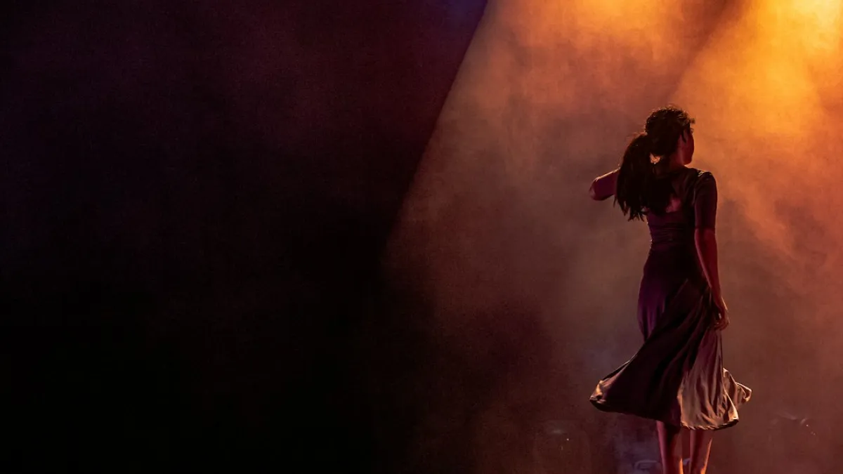 Female dancers on stage for a story based performance amid beautiful light effects and graceful movement.