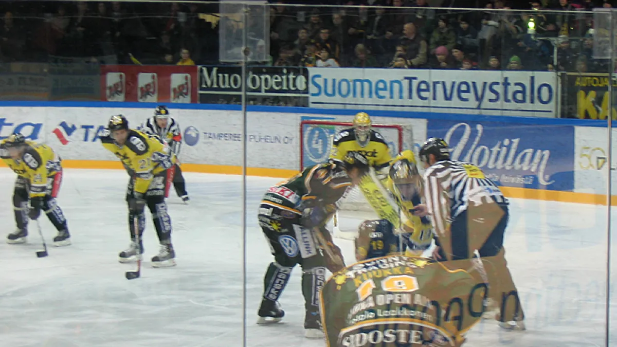An SM-liiga ice hockey game between Ilves Tampere (green) and SaiPa Lappeenranta (yellow). Players are, from the left: #24 Marko Ojanen, #21 Ossi-Petteri Grönholm, #41 Raimo Helminen, #72 Rob Zepp (goaltender), green #19 Mikko Kuukka, yellow #19 Mikko Hakkarainen.