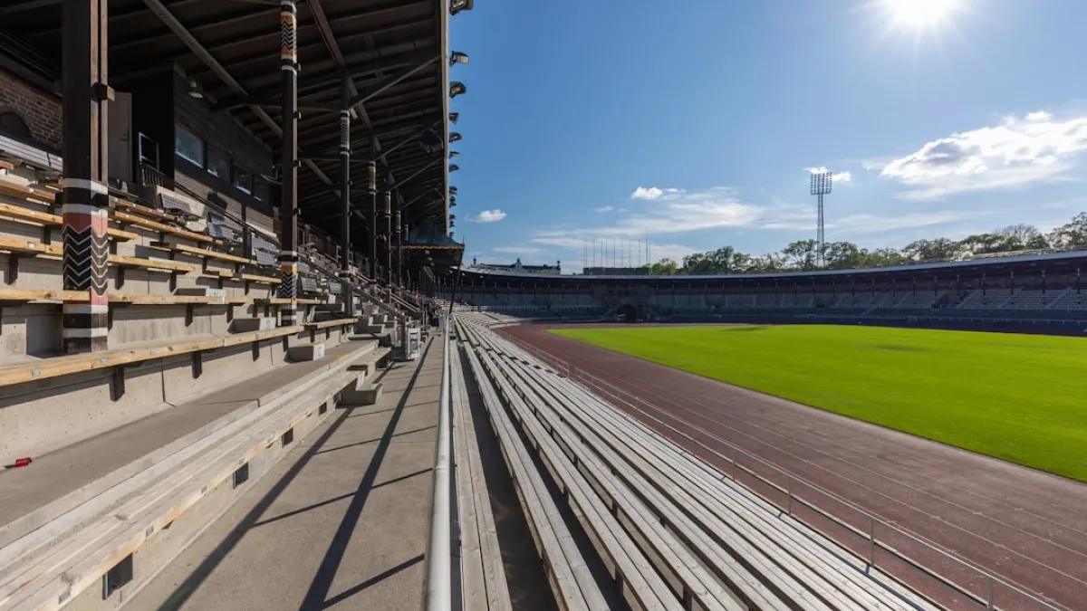 Empty stadium seating and track under sunny sky