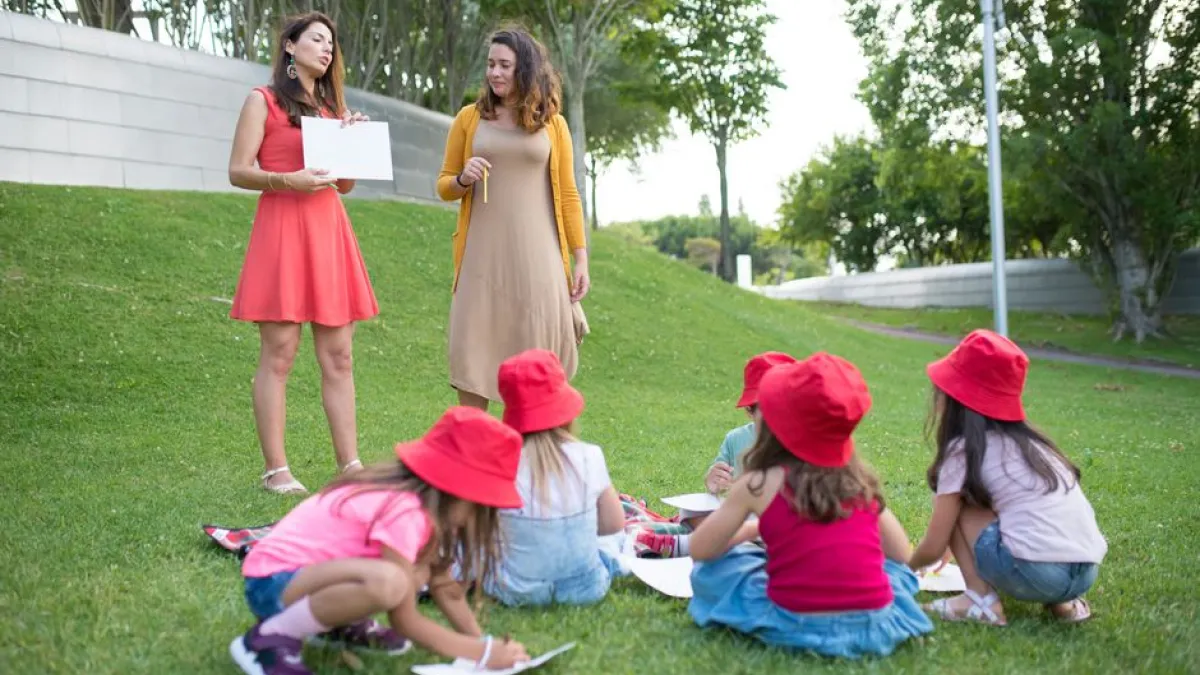 Girls engaged in an outdoor educational activity with two women educators.